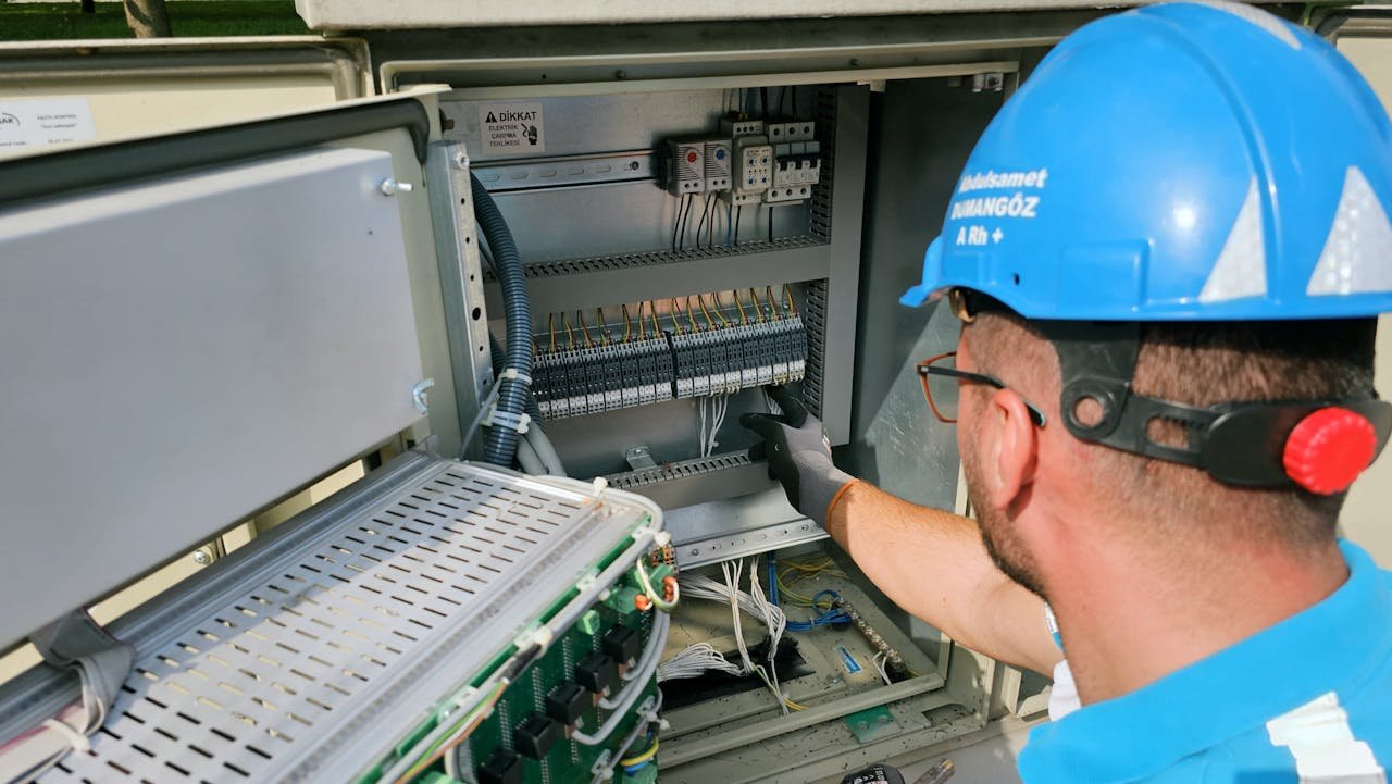 gallery-1 An electrician works on an outdoor fusebox, ensuring safety and functionality.